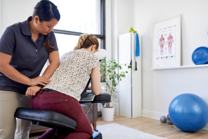 massage therapist giving neck and back treatment