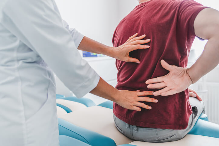 orthopedist examining patient's back