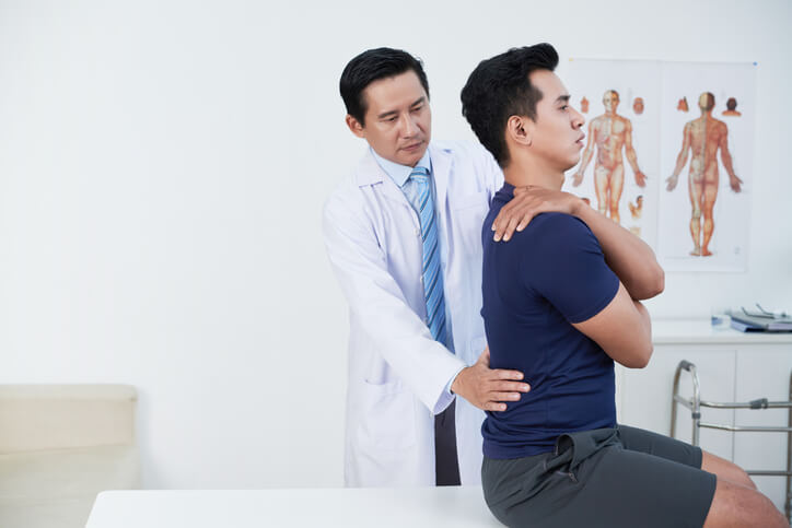 orthopedist examining patient's back